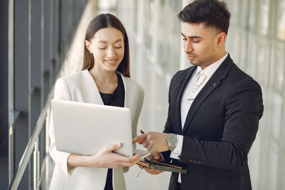 Concentrated diverse male and female employees in formal clothes discussing a business project.